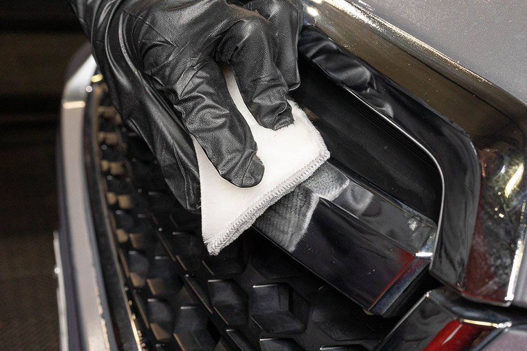 Water Spot Remover Applying on Front Grill of Silver Car